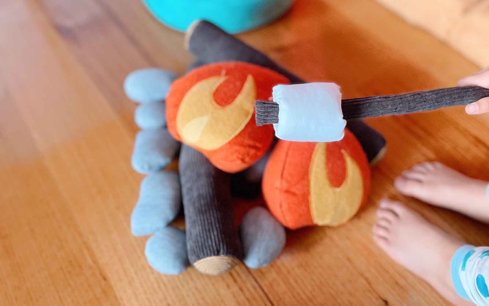 A Pretend Campfire set with felt flames and marshmallow stick on a rug